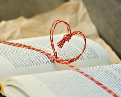 A bedside table with a warm reading lamp focused on a book, creating a relaxing evening mood